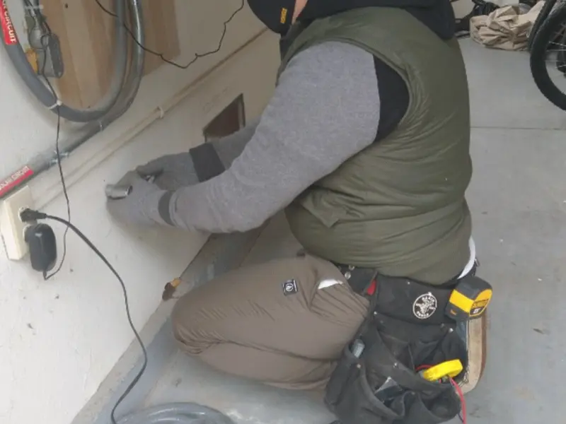 Electrician performing outlet wiring in a Franklin garage